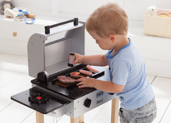 Kind an Holz Spielzeuggrill