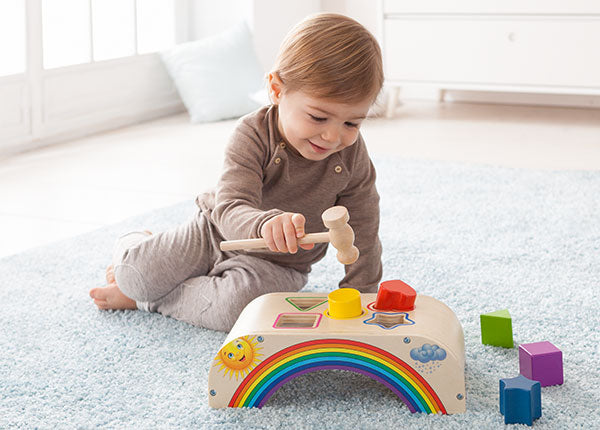Baby spielt mit Holzspielwaren