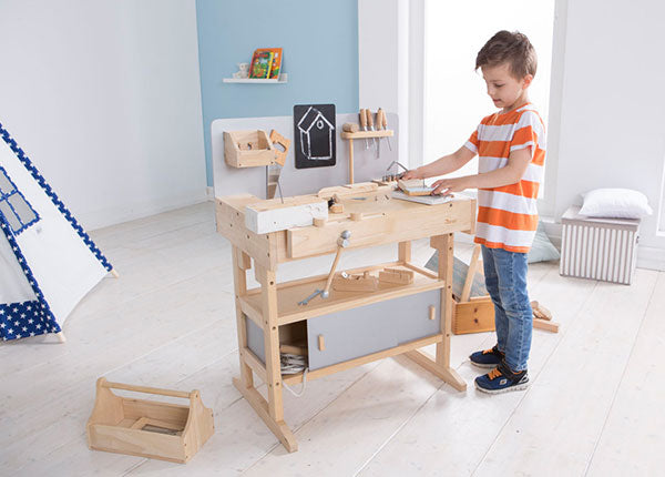 Junge spielt mit Holz Werkbank