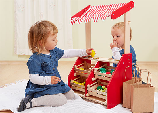 Kinder spielen mit Holz Kaufmannsladen