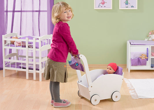 Kind schiebt Puppe im Holz Kinderwagen