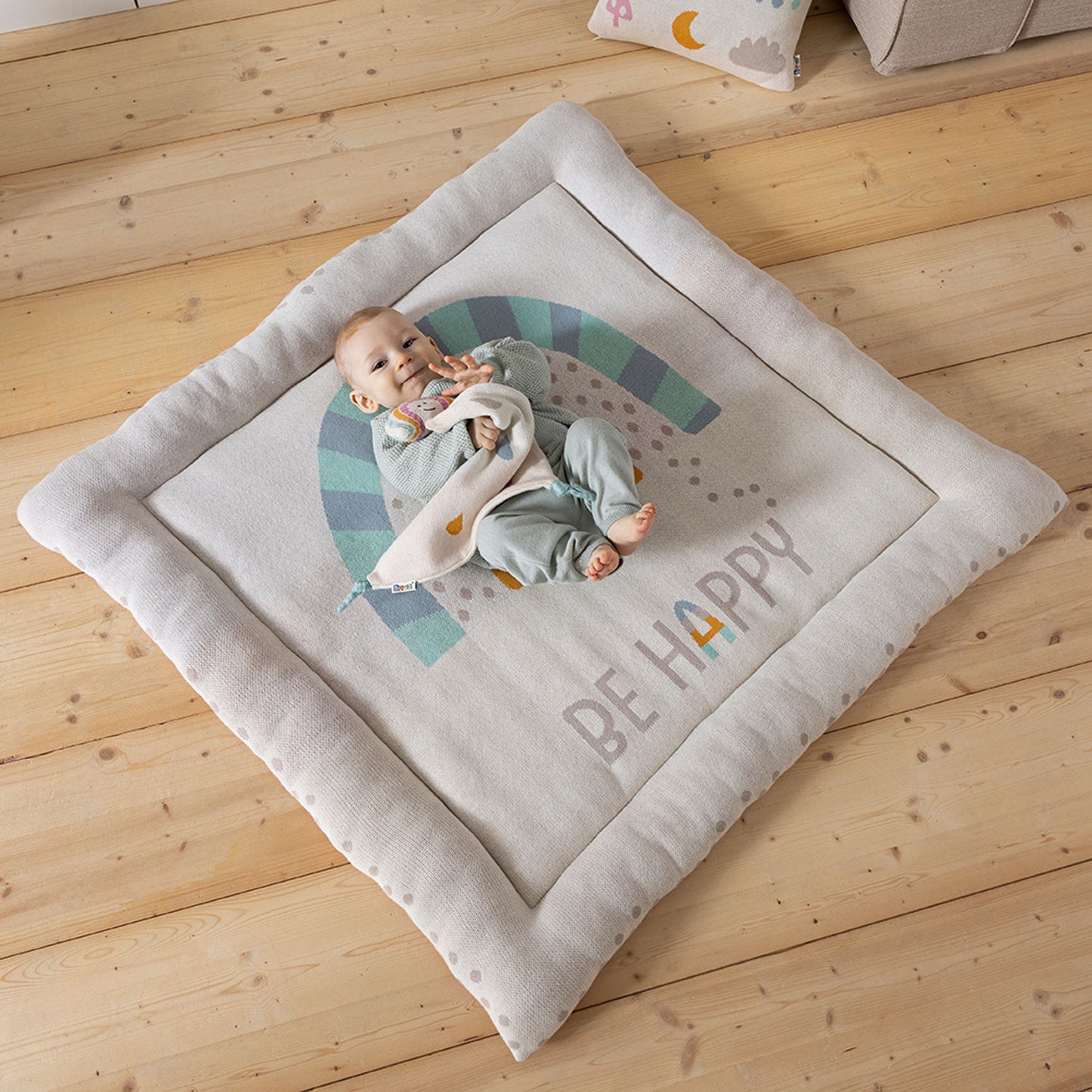 Baby mit Schmusetuch auf Krabbeldecke