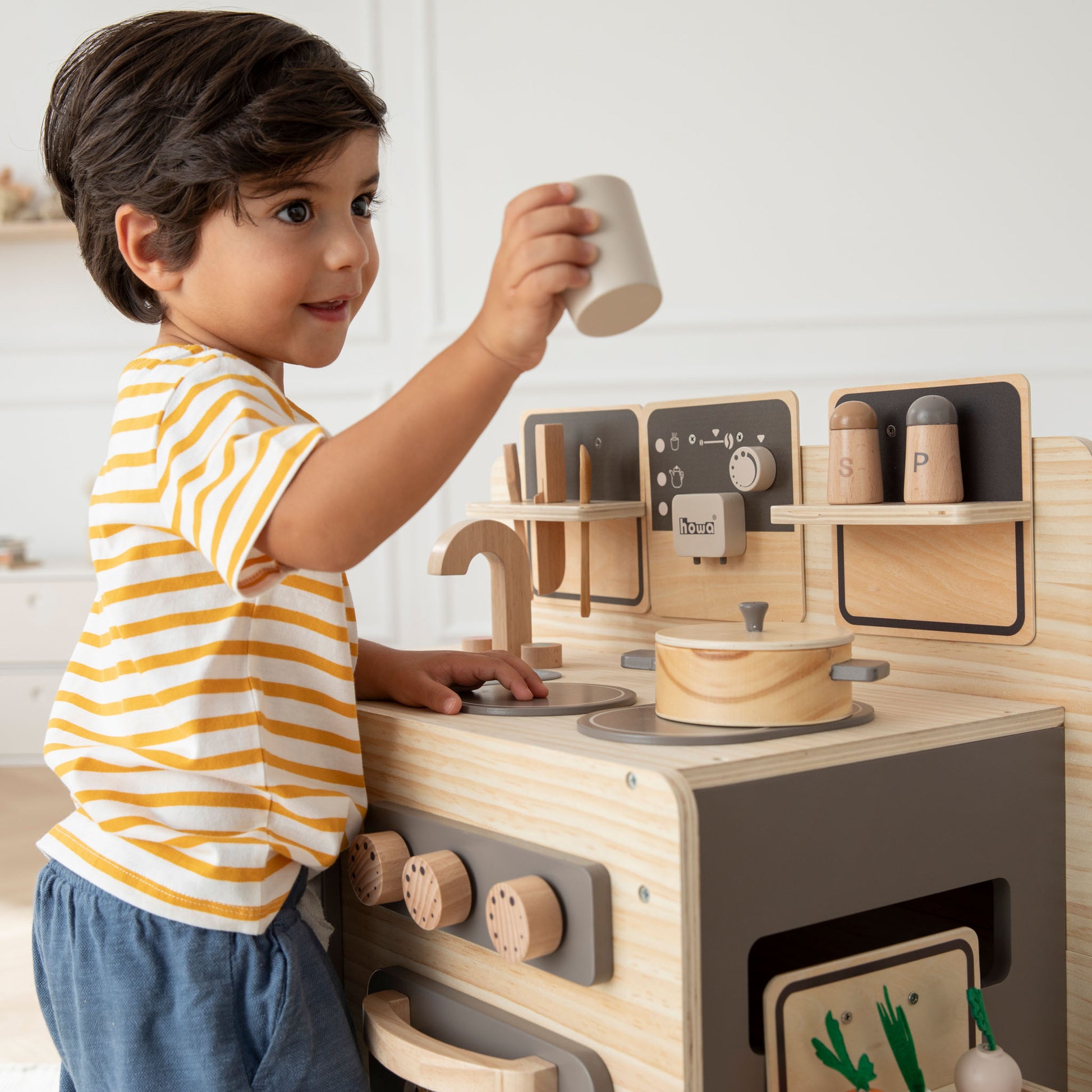 Kind mit Tasse der Kinderküche