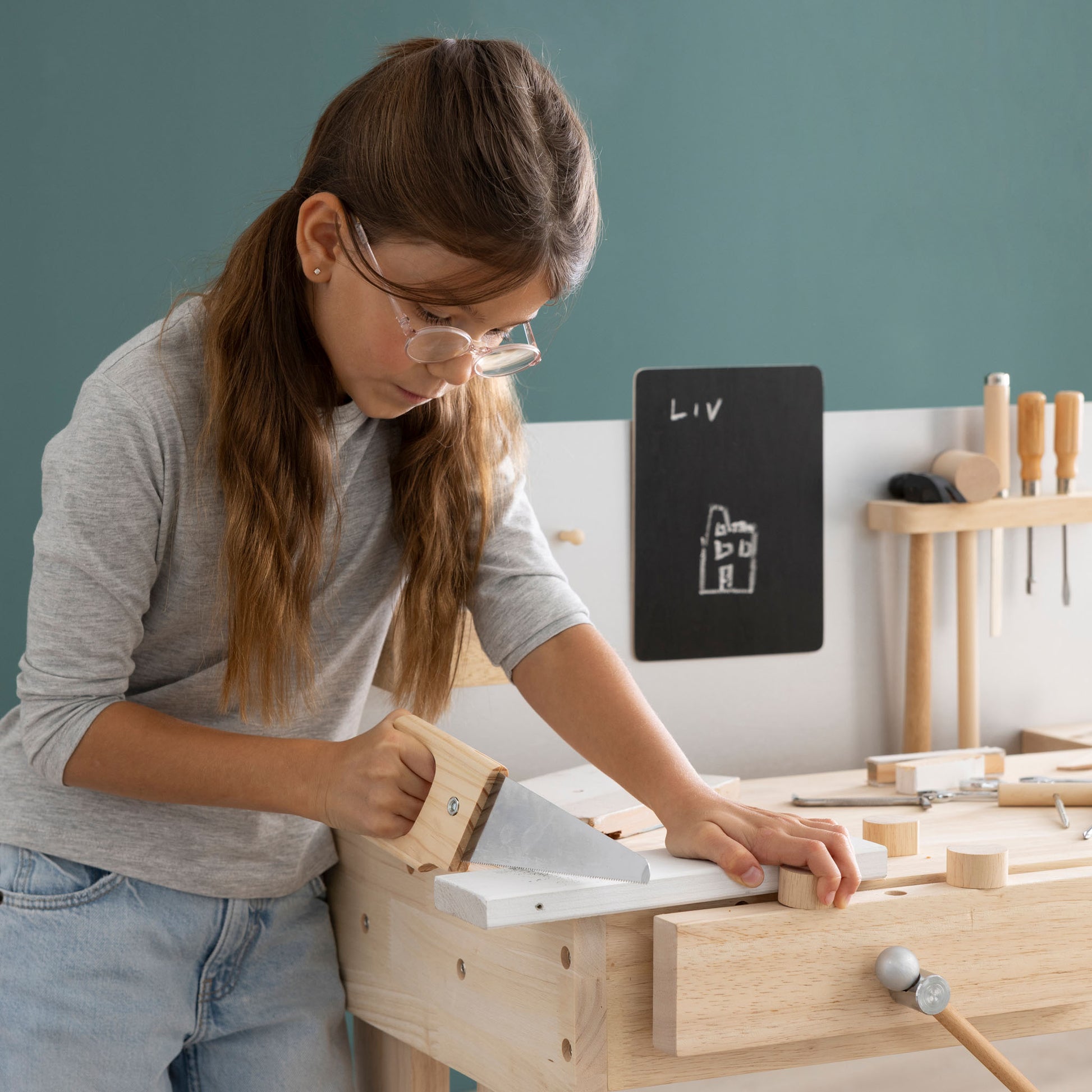 Kinderwerkbank mit Kind beim sägen